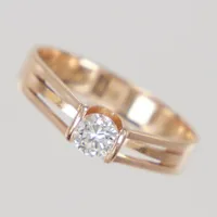 Ring med briljantslipad diamant ca 0,22ct enligt gravyr, kvalitet ca W-TCr/VS, mindre nagg på rondisten, stl 16, bredd 3,5mm, tillverkad av Guldfynd AB, år 1985, 18K guld Vikt: 1,9 g