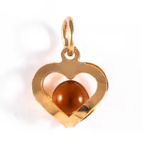 Berlock "hjärta med orange kula" i 18K guld. Den är 13,4 mm lång inkl. ögla och väger 0,5g. Stämplad NSE ( NSE Guldvaru Aktiebolag ).
