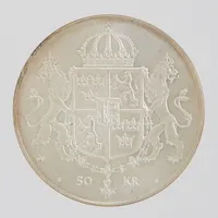 Silvermynt, Ø36mm, Det kungliga bröllopet 1976, KONUNG·CARL·XVI·GUSTAF/ DROTTNING·SILVIA/19·JUNI·1976, nominellt värde 50 kronor, finhalt 925/1000. Vikt: 27,2 Vikt: 27,2 g