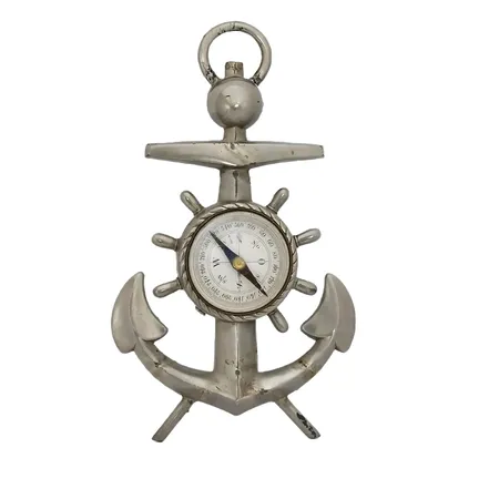Kompass, monterad i ankare, äldre modell, tennliknande material, har ursprungligen varit försedd med stödben (saknas), fungerande, höjd 14 cm, bredd 8,5 cm, märkt på baksidan, bruksmärken, ögla bruten i nedre kant, en dekor saknas, vikt strax över 100 gram 