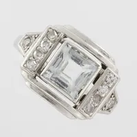 Ring med Akvamarin kantskader och diamanter ca 10x0,02ct, stl 14½mm, bredd 1,9-11,7mm, 18k vitguld ostämplad Vikt: 4,4 g