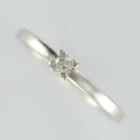 Ring med diamant, 0,08 enligt gravyr, stl ca 18, bredd 2mm, vitguld, 18K  Vikt: 2,8 g