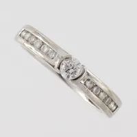 Ring med diamanter 0,30ct enligt inskription ca 1x0,15 och 12x0,0125ct, stl 16mm, bredd 3mm, Guldfynd, 18k vitguld Vikt: 3,1 g