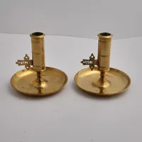 Ett par ljusstakar i mässing, tillverkade av Skultuna, cylindrisk med randdekor, höjd ca 11cm, Ø11,5cm, använt skick.  Vikt: 0 g