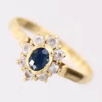 Ring med vita stenar samt en blå sten, troligen safir, stl 15½, bredd 2-10mm, 18K  Vikt: 2 g