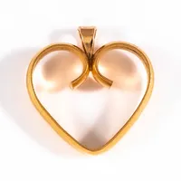 Berlock "hjärta"; tillverkad av en ring i 23K guld med en fast ögla i 18K guld. Den är 21,5 mm lång inkl. ögla och väger 5,1g. 