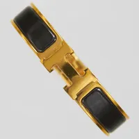 Armband, Hermès Clic Clac H, guldfärgad metall med svartemalj, ca 55x45mm, märkt Hermès Made in France, bredd:11,5mm, ytliga repor, inga tillbehör