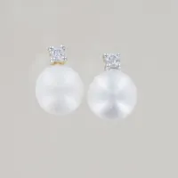 Ett par örhängen med pärla/diamant 0,01ct, bredd 6 mm, ploppar saknas, 18K  Vikt: 0,9 g