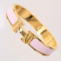 Armband Hermès, Clic Clac H, guldfärgad metall med rosa emalj, numrerad: SP 12 12, innermått ca 50x60mm, bredd 12mm, manual, box, dustbag