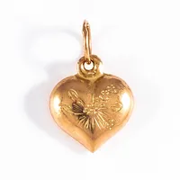 Berlock "hjärta med graverat blomstermönster" i 18K guld. Den är 13,2 mm lång inkl. ögla och väger 0,3g. 