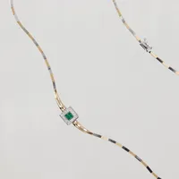 Collier, halvstelt, 44cm, bredd ca 2mm, integrerad hänge dubbelsidig/vridbar, ena sidan prinsesslipade diamanter 16x ca 0,015ct samt 4st gröna stenar möjligen smaragder, andra sidan 16st blå stenar möjligen safirer, Ø 9,3mm, gul/vitguld blank/borstad dekor, smärre repor, 14K  Vikt: 15,5 g