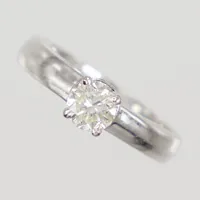 Ring, diamanter 1x ca 0,60ct ca TCa/SI samt 13x ca 0,01ct, stl 16¾, Ø 5,3mm, skenas bredd 3,6mm, höjd 8,1mm, vitguld 18K  Vikt: 5,1 g