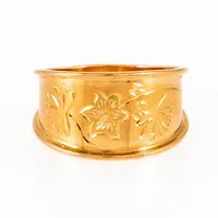Ring i 18K guld med ett graverat blomstermönster. Den är 3,8 - 10,8 mm bred, är i storlek 16½ och väger 2,7g. Tillverkad av Isaks Gravyrsmedja i Kolsva. Stämplad 18K. Gravyr.