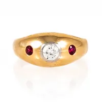 Lordring i 18K guld med två röda stenar och en diamant c:a 0,35ct (c:a W-si, fin lyster); fattad i vitt guld. Den är 3,4 - 9,7 mm bred, är i storlek 19½ och väger 7,5g. Oläslig stämpel. 
