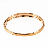 Stelt, öppningsbart armband i 18K guld. Det är 5 -8,9 mm brett, har ett innermått på 17,5 cm och väger 30,0g. Kistlås. Tillverkat 2000 av Bengt Hallbergs Guldsmeds AB i Köping. Kattfot.