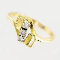 Ring, diamanter 2 x ca 0,04ct, 1 x ca 0,05ct, stl 17¾, bredd 1,5-9mm, nagg på diamant, 18K.  Vikt: 3 g