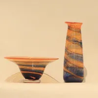 Vas och skål på fot, Staffan Gellerstedt (född 1944), blå och orange marmorerad glasmassa, signerade, skålens höjd 10, diameter 20, vasens höjd 22cm Vikt: 0 g