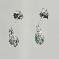 Ett par örhängen med gröna glasstenar samt diamanter ca 0,20ctv, längd 14 mm, bredd 6 mm, defekt/större nagg på grön glassten, vitguld, 18K. Vikt: 2,2 g