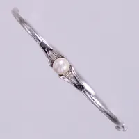 Armring med odlad pärla Ø ca 5,8mm och diamanter, 2 x ca 0,01ct, inre bredd ca5,7cm, bredd ca 2,3-6,6mm, vitguld 18K Vikt: 6,6 g