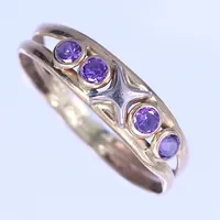 En ring med lila stenar, stl 18½, bredd 3-5mm, 18K Vikt: 1 g