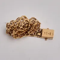 Armband i 18K guld, 19cm, X-länk med stav, bredd 10,5mm, 1st låsåtta saknas, tillverkad av Ekström Aktiebolag, år 1969, vikt 25,29g.