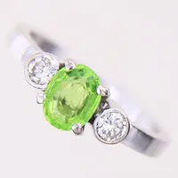 Ring med grön sten samt briljantslipade diamanter 2 x 0,12ct, stl: 17½, bredd 2,4-7,1mm, grön sten med slitage samt sitter något löst i fattning, ostämplad, vitguld 18K.   Vikt: 4,8 g