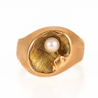 Pärlmussle-ring i 18K guld med en 4 mm´s odlad pärla. Den är 3,2 - 12,9 mm bred, är i storlek 17¼ och väger 3,3g. Tillverkad 1957 av Heribert Engelbert i Stockholm. Kattfot. Signaturstämplad Stigbert.