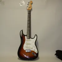Elgitarr Fender Stratocaster, USA, år 1989-1990.serienummer E 938903, Sunburst, Jumboband, Noiselesspickuper, låsbara stämskruvar, stötskada på framsida kropp, repor, gitarren är i gott spelbart skick, huvudet har en gammal skada under stämskruvarna, bra lagat, sliten gigbag medföljer, inga andra tillbehör,