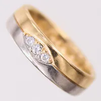 Ring med briljantslipade diamanter tot 0,07ct enligt gravyr, stl: 15½, bredd 4,8mm, gravyr, vit/gult guld 18K.  Vikt: 5,2 g