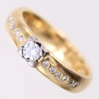 Ring med briljantslipade diamanter 1 x 0,15ct, 12 x 0,01ct, stl: 16, bredd 4mm, 18K.  Vikt: 4,7 g
