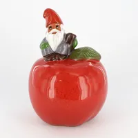 Figurin, Rolf Berg, Tomte sittande på ett äpple, ca 16,5cm, nr Torshälla, Sweden, etikettmärkt Vikt: 0 g Skickas med paket.