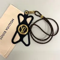 Telefonhållare Louis Vuitton, Louise, Noir, modell M68382, svart silikon, repor på gulmetall,  kvittokopia Birger Jarlsgatan, daterat 24/3/20, dustbag. 