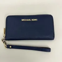 Plånbok Michael Kors, blått läder, mått ca 17x9,5cm, handledsrem, slitage på gulmetall, inga tillbehör. 