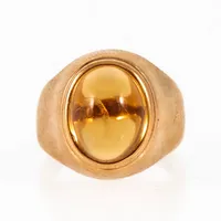 Ring i 18K guld med en orange sten. Den är 2,9 - 14,4 mm bred, är i storlek 14½ (OBS! liten!) och väger 5,5g. Tillverkad 1961 av Inga Malm i Boden. Kattfot.
