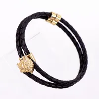 Armband Versace, svart flätat läder med detaljer i guldmetall, längd 21,5cm, nyskick. 