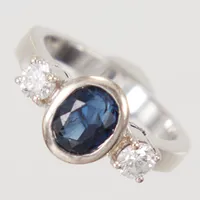Ring, stl 17½, diamanter 2x ca 0,23ct, varav en troligen syntetisk, samt en oval fasetterad safir ca 5 x 7mm, , bredd 2,9 - 9,9mm, vitguld 18K  Vikt: 7,1 g