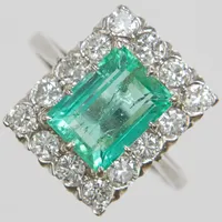 Ring, smaragdslipad smaragd 2,32ct enligt gravyr, briljantslipade diamanter 12xca0,13ct totalt 1,60ctv enligt gravyr, ca TW/VS, Ø17¼, bredd:1,3-15mm, smaragden är infärgad, importstämplad, vitguld, 18K. Vikt: 4,6 g