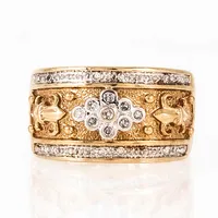 Ring i 9K guld med 17 diamanter á c:a 0005ct; fattade i vitt guld. Den är 2,2 - 11,5 mm bred, är i storlek 16½ och väger 5,4g. Engelska stämplar & 375.