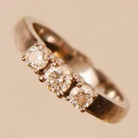 Ring, briljantslipade diamanter 2xca0,15ct + 1xca0,19ct, ca W/SI2, Ø16½, bredd:3-3,9mm, GHA, vitguld, 18K. Vikt: 5 g