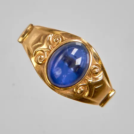 Ring med en cabochonslipad syntetisk safir, Ø18¼, bredd: 3-10,4mm, 18K, 3,4g.