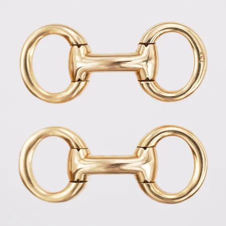 Ett par manschettknappar, Hermès, horse bit eller 'Mors de Filet', snr: 17533, längd 36mm, bredd 15mm, franska kontrollstämplar, 18K guld.  Vikt: 20,3 g