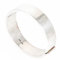 Stel, öppningsbart armband i silver. Det är 18 mm brett, har ett innermått på 19 cm och väger 40,7g. Kistlås. Stämplat 925 JAa (Jens Aagaard). 