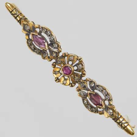 Brosch, 1 rundslipad och 2 navettslipade rubiner, åttkantslipade diamanter 26xca0,01ct, 55x11mm, 18K Vikt: 5,6 g