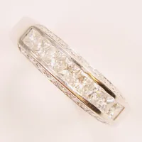 Ring, princesslipade diamanter 8x ca 0,10ct, briljantslipade 18x ca 0,02ct, Ø18, bredd:3-5mm, vitguld, 18K 5,3g.