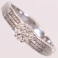 Ring med diamanter 1x ca 0,04ct, 6x ca 0,02ct, 20x ca 0,005ct, stl 18½, bredd 2,2-5,5mm, vitguld, GHA, 18K  Vikt: 4 g