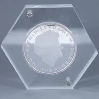 Minnesmedalj i silver "ASTRID LINDGREN 1907 - 2002". Förgylld dekor. Ø 100mm 1000g 999/1000 silver. Monterad i plexiglas. Bruttovikt 1630g.  Skickas med postpaket.