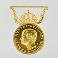 Förtjänstmedalj Carl XVI Gustaf, 23K guld med bandfäste i 18K, Ø27 mm, namngravyr, viktfördelning 23K ca 10g, fäste 18K ca 3,6g