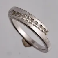 Ring i silver, stl 19, bredd 2,6-5,3mm, 9st vita stenar mått 2,2x2,2mm, 925/1000, tillverkad av Guldfynd, vikt 3,48g.