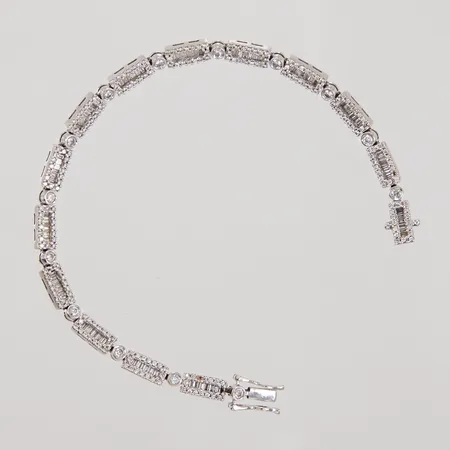 Armband, längd 18cm, bredd 4mm, diamanter ca 14x0,04ct, ca 200x0,005ct, samt små baguetter, diamanter saknas, otydliga stämplar, vitguld, 18K Vikt: 16,5 g