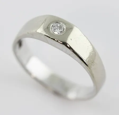 Ring med diamant ca 0,10ct, stl  20,½mm, bredd ca 4,4-6,5 mm, 14k vitguld  Vikt: 7,2 g